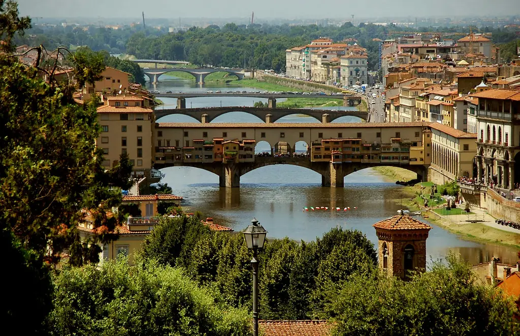 Florence: The Ponte Vecchio as seen from the hills in the western parts of Florence brown concrete building near river during daytime