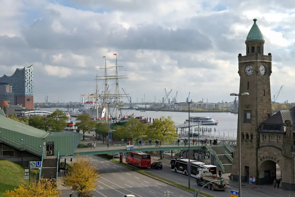 Hamburg: A busy day at Hamburg's harbor featuring the Elbphilharmonie, historic ships, and clock tower.
