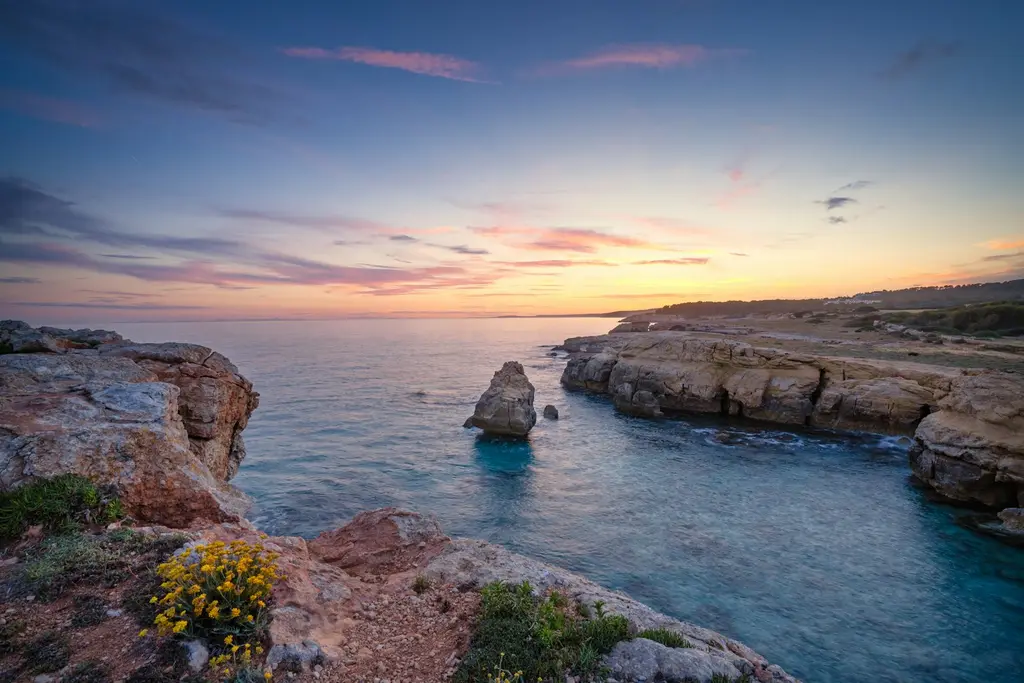 Menorca: Beautiful sunset at Menorca, Spain rocky hill showing blue sea under blue and white skies
