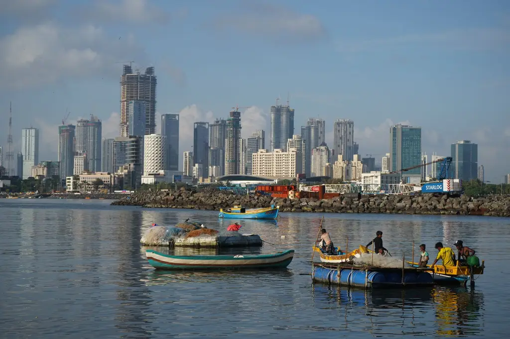 Mumbai: Vibrant view of Mumbai's skyline with local fishing boats on the water, capturing urban and traditional life.