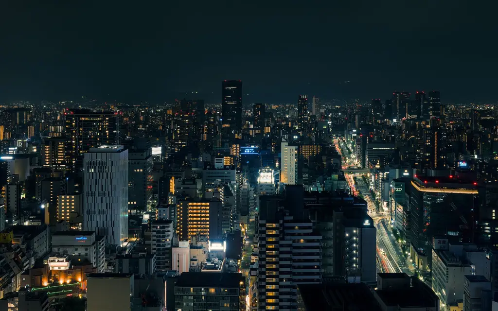 Osaka: A beautiful nighttime cityscape of Osaka, Japan, with illuminated buildings and streets.