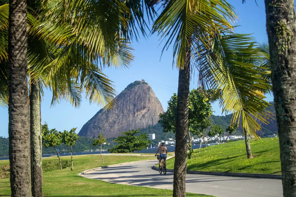 Rio de Janeiro: A cyclist rides through a park with a view of the iconic Sugarloaf Mountain in Rio de Janeiro.