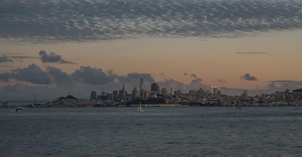 San Francisco: Beautiful view of San Francisco skyline with tranquil waters and a dramatic sunset sky.