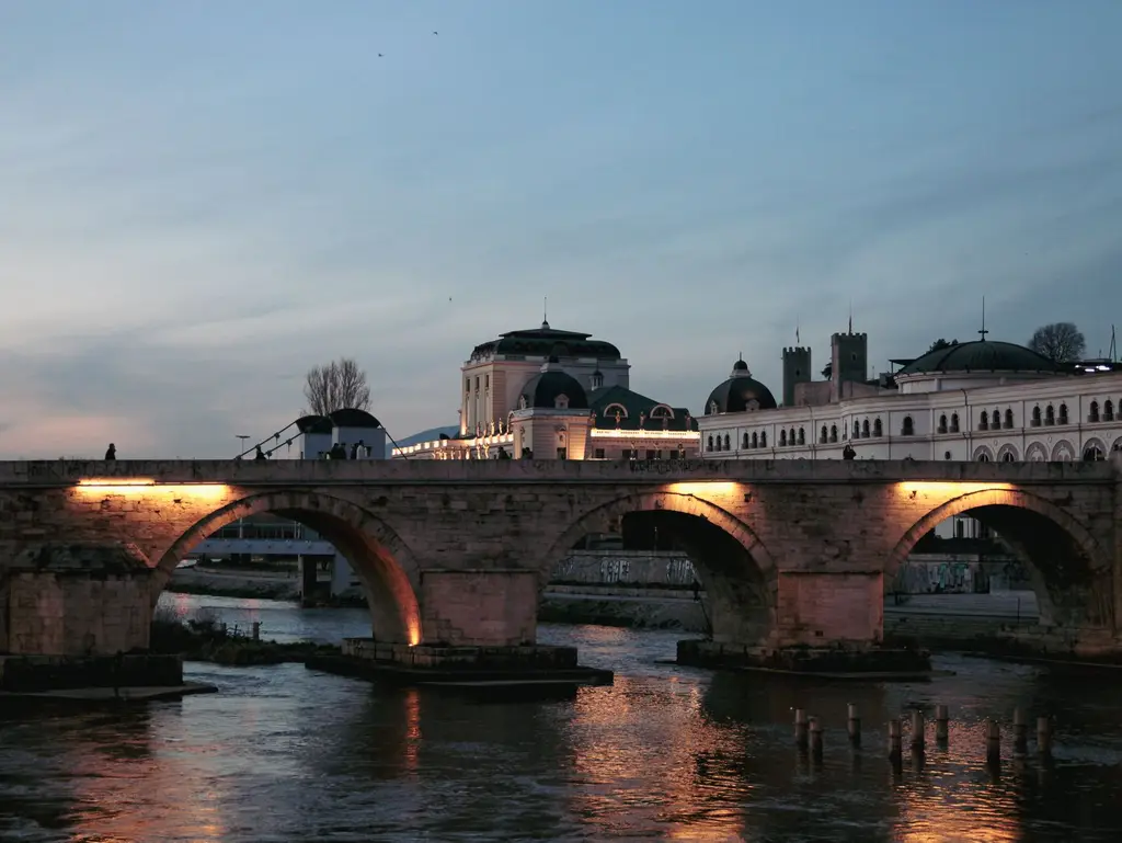Skopje: Evening shot of Stone Bridge over Vardar River in Skopje, illuminated by lights.