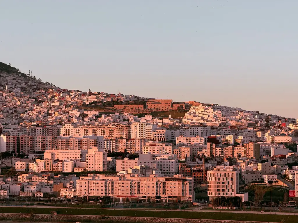 Tangier: Vibrant sunset over Tangier showcasing residential architecture and the vivid hues of the city's landscape.
