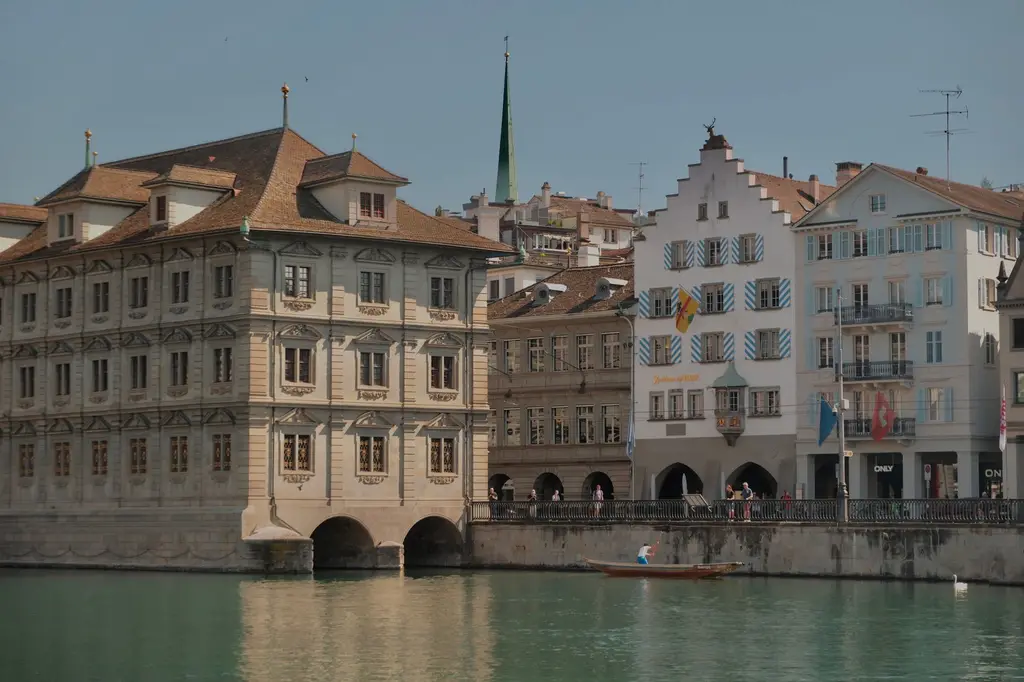 Zurich: Scenic view of Zurich's historic buildings along the Limmat River, capturing Swiss architectural charm.